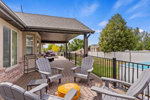 Deck with a fenced in pool and a yard