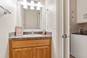 Bathroom featuring vanity and washer / clothes dryer