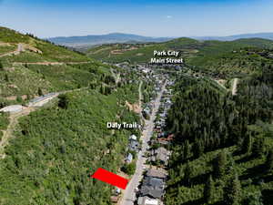 Aerial overview of property's location with a heavily wooded area and mountains