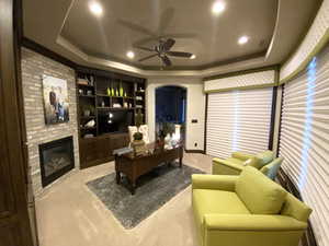 Primary Bedroom Study, featuring a fireplace, a raised ceiling, and ceiling fan