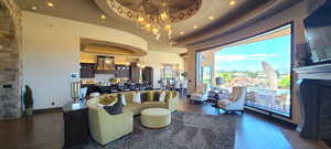 Living room with dark wood-type flooring, a chandelier, and a tray ceiling