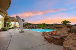 Outdoor pool with a patio and an outdoor fire pit