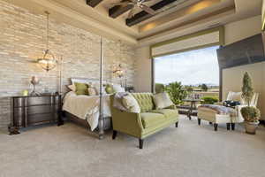 Bedroom featuring brick wall, a tray ceiling, carpet flooring, and a high ceiling