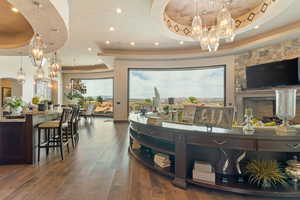 Interior space with an inviting chandelier, recessed lighting, a tray ceiling, and wood-type flooring