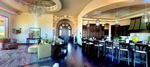 Kitchen with a tray ceiling, dark wood-type flooring, a chandelier, and decorative light fixtures