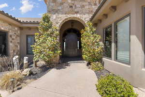 View of exterior entry with stone siding and stucco siding