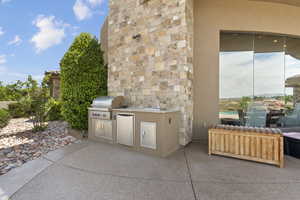 View of patio with a sink, area for grilling, radiator heating unit, and exterior kitchen