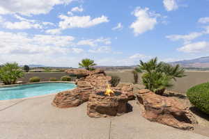 View of swimming pool featuring a mountain view, a patio, a fenced in pool, and an outdoor fire pit