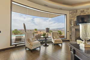 Sitting room with a fireplace, visible vents, dark wood finished floors, and baseboards