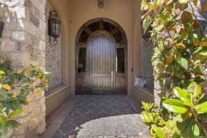 Doorway to property with stone siding and stucco siding