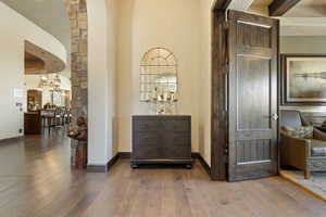 Hall featuring a chandelier, baseboards, and wood-type flooring