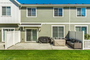 Rear view of house featuring an outdoor living space, a lawn, and a patio area