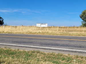 View from across street to North, tall garage door to shed