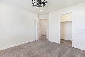 Carpeted  bedroom with ceiling fan.