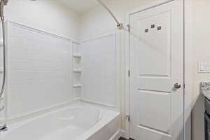 Bathroom with shower / bathing tub combination and vanity.