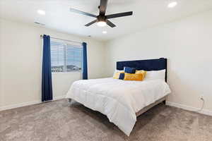 Carpeted bedroom featuring ceiling fan.