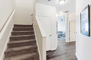 Entry with stairs, coat closet and hallway to family room and kitchen.