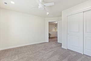 Carpeted  bedroom with ceiling fan.