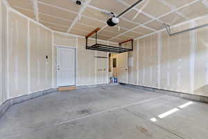 Garage with a garage door opener and overhead storage.