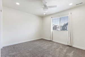 Carpeted  bedroom with ceiling fan.