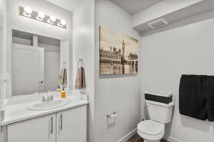 Bathroom featuring vanity, toilet, and hardwood / wood-style floors