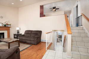 Living room with a fireplace, hardwood / wood-style flooring, and ceiling fan