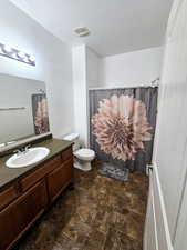 Bathroom with vanity, toilet, a shower with shower curtain, and a textured ceiling