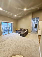 Carpeted living room with vaulted ceiling