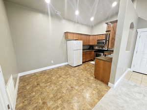 Kitchen with high vaulted ceiling and stainless steel appliances