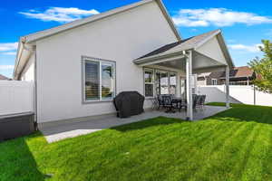 Rear view of house featuring a lawn and a patio