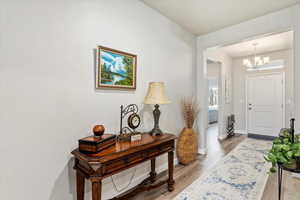 Entryway featuring light hardwood / wood-style flooring and an inviting chandelier