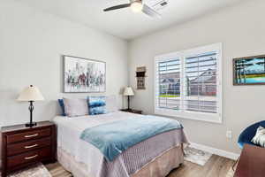 Bedroom with ceiling fan and light wood-type flooring