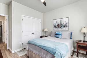 Bedroom with a closet, ceiling fan, and light hardwood / wood-style flooring