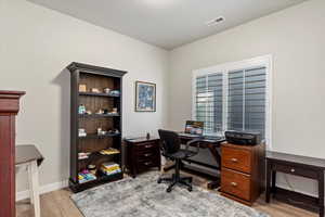 Home office with light hardwood / wood-style floors