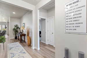 Corridor with light hardwood / wood-style flooring