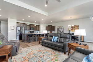 Living room with light hardwood / wood-style flooring and ceiling fan with notable chandelier