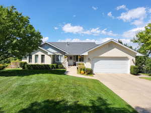 Single story home featuring a front yard and a garage