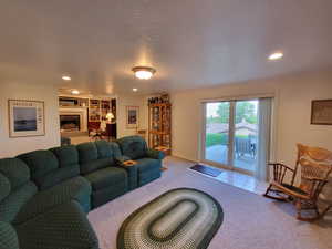 Living room with a textured ceiling and light colored carpet