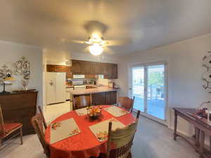 Carpeted dining space featuring ceiling fan, sink, and ornamental molding