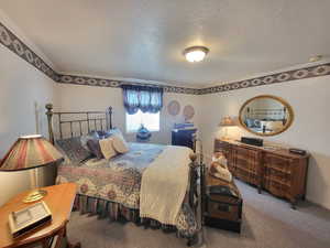 Bedroom featuring carpet floors and a textured ceiling