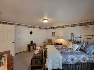 Bedroom with a textured ceiling and carpet floors