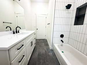 Bathroom featuring tiled shower / bath and vanity