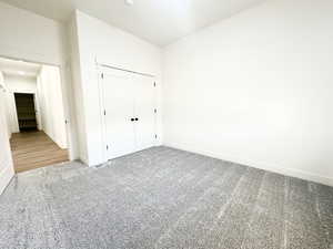 Unfurnished bedroom featuring carpet flooring and a closet