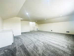 Additional living space featuring a textured ceiling, lofted ceiling, and carpet floors