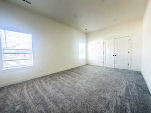 Carpeted empty room featuring a wealth of natural light