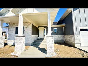 Property entrance with a garage and covered porch