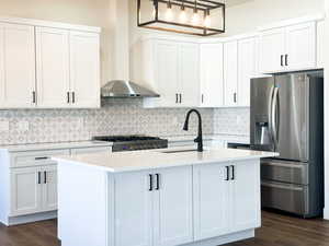 Kitchen with a kitchen island with sink, dark wood-type flooring, stainless steel appliances, and sink