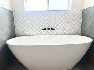 Bathroom with a tub to relax in and tile patterned flooring