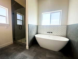 Bathroom featuring tile walls and shower with separate bathtub