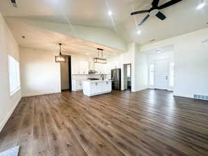 Unfurnished living room with lofted ceiling, ceiling fan, dark hardwood / wood-style floors, and sink